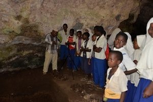Salim Salim (Department of Archives, Museums, and Antiquities, Pemba) teaches a local school group about the prehistory of the cave