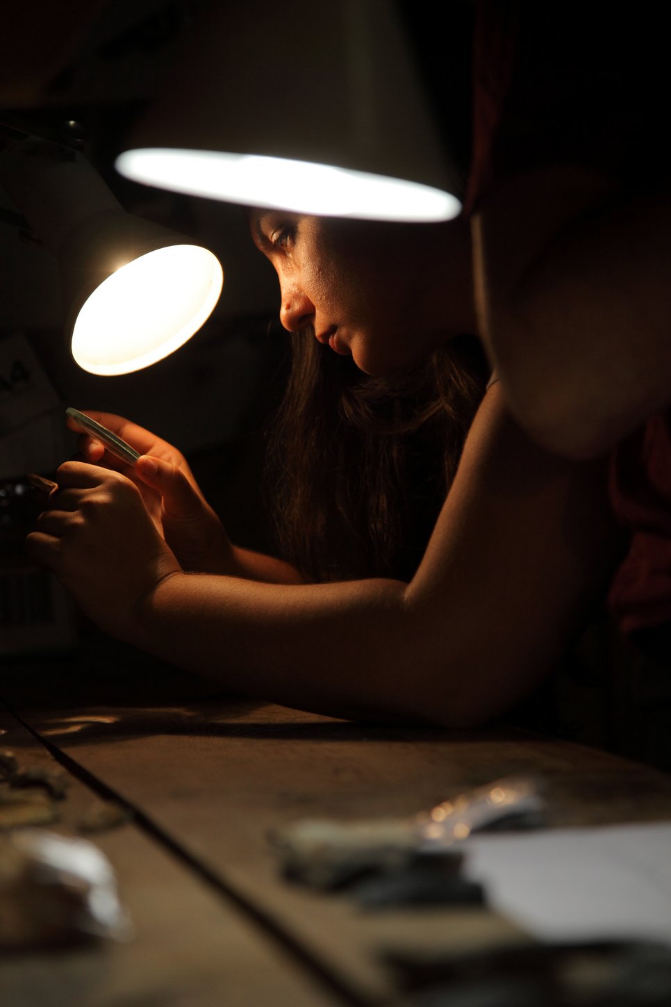 Katerina Douka at the Denisova Cave basecamp examining bones for butchery marks prior to sampling for radiocarbon dating.